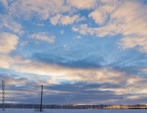 Winter sunset over snowy field.