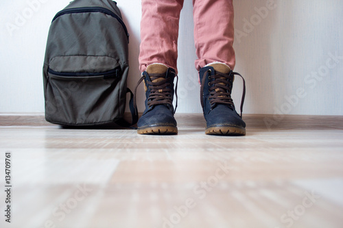 backpack and boots on the background wall and the flooring