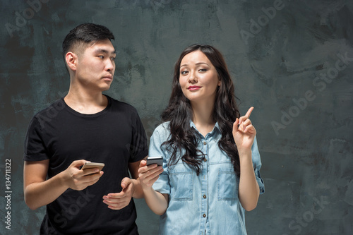 Asian young couple using cellphone, closeup portrait.