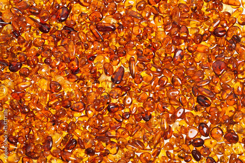 Slika na platnu Dark yellow amber stones on a white background.