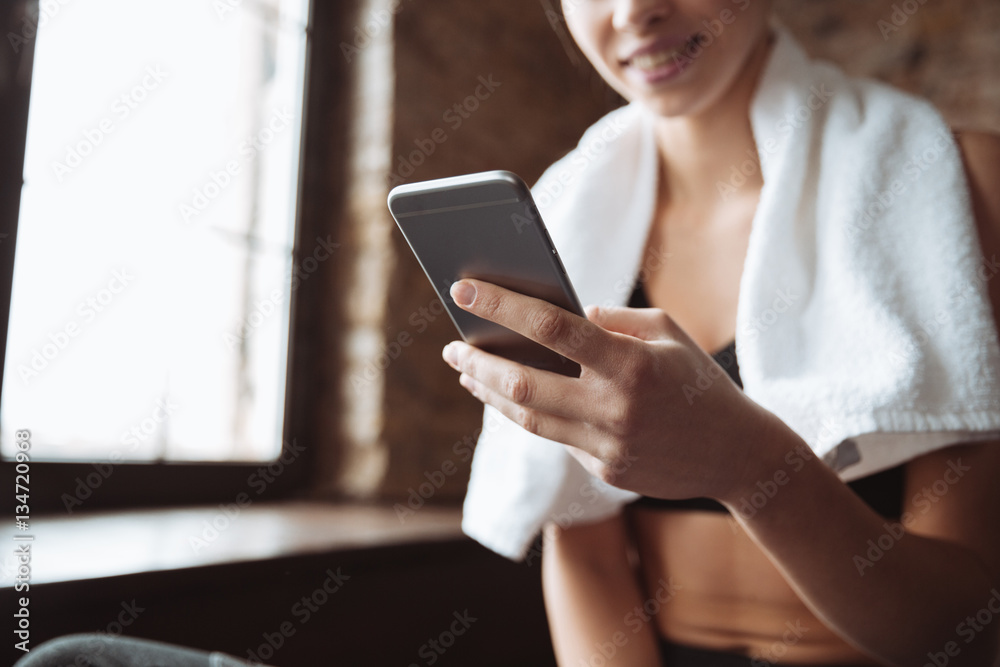 Cropped picture of young fitness woman chatting by phone. Cropped picture of young fitness woman chatting by phone.
