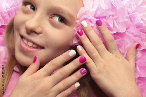 Pink white children's manicure for the girl with the flower.