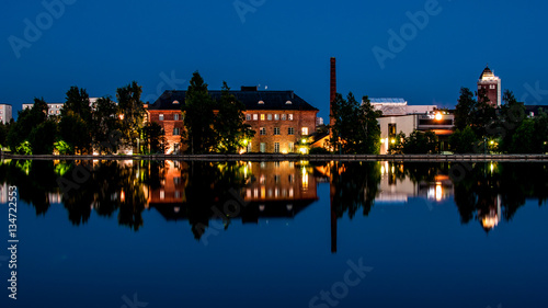 Old factory upgraded into an hotel in Finland city, with reflections in artificial lagoon