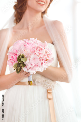 Bridal bouquet Beautiful of pink wedding flowers in hands of the bride