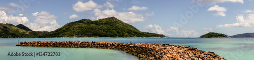 Foto Large panorama of a tropical island taken from the coast with a jetty made of st
