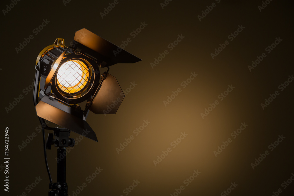 Fototapeta premium Halogen spotlight with a Fresnel lens. Spot light on the wall. TV, video, photo, shooting