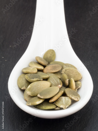 White ceramic spoon with pumpkin seeds