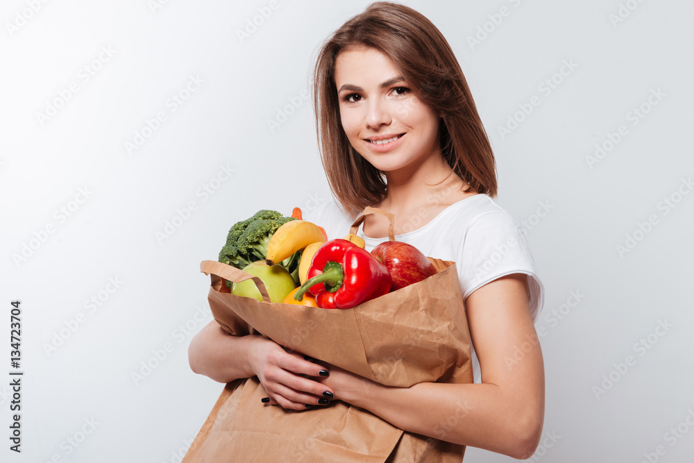 Cheerful young lady holding fruits and vegetables Cheerful young lady holding fruits and vegetables
