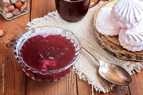 Hot drink from fruit (kissel), amarshmallow and nuts on a wooden