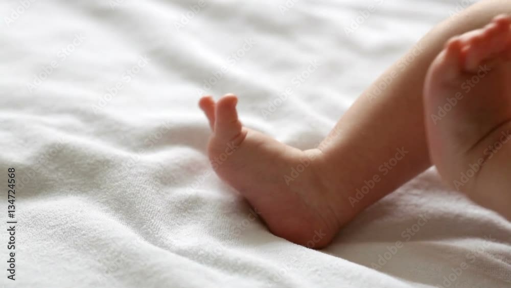 Little moving feet of lying newborn baby, closeup Little moving feet of lying newborn baby, closeup