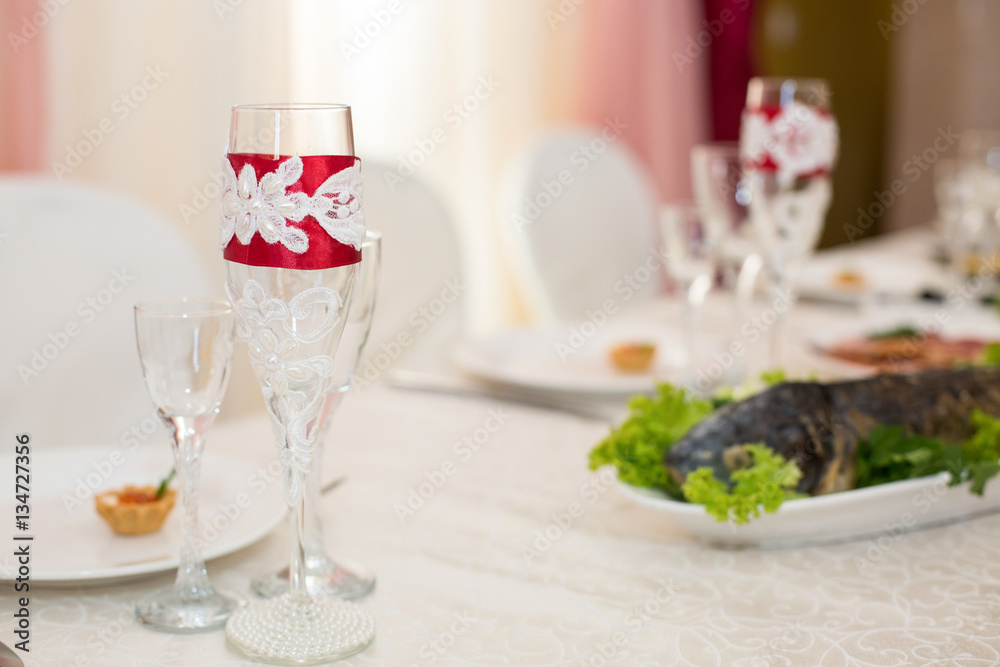 Champagne flute decorated with red silk ribbon and lace with pea