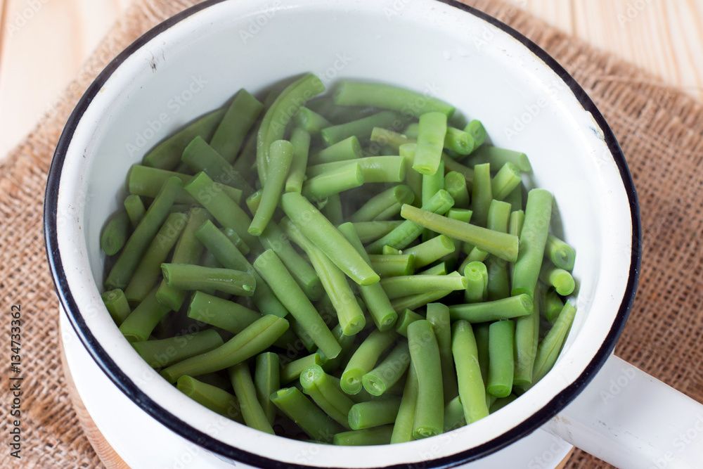 Colander with raw green bean on the cutting board Colander with raw green bean on the cutting board