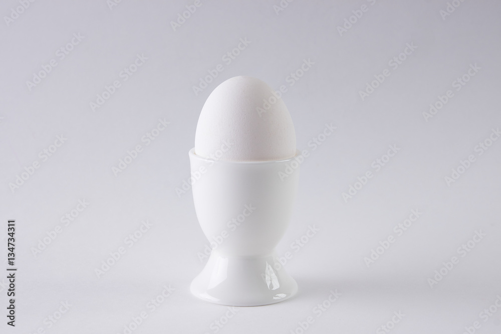 Egg in egg cup on white background