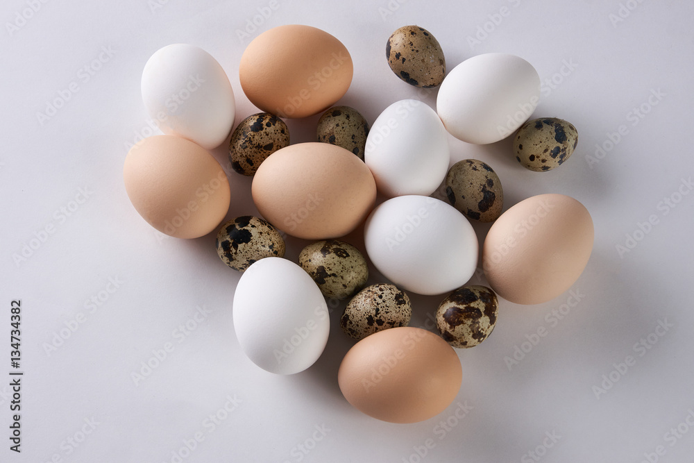 Chicken and quail eggs on white background. Top view Chicken and quail eggs on white background. Top view