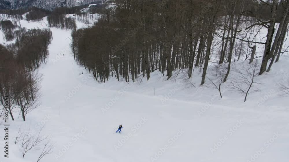 Rider alone skiing from the mountains of ski resort. Aerial view. Rider alone skiing from the mountains of ski resort. Aerial view.