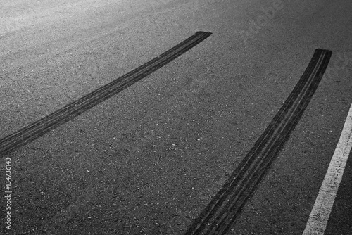 Abstract asphalt road background with crossing of tires tracks