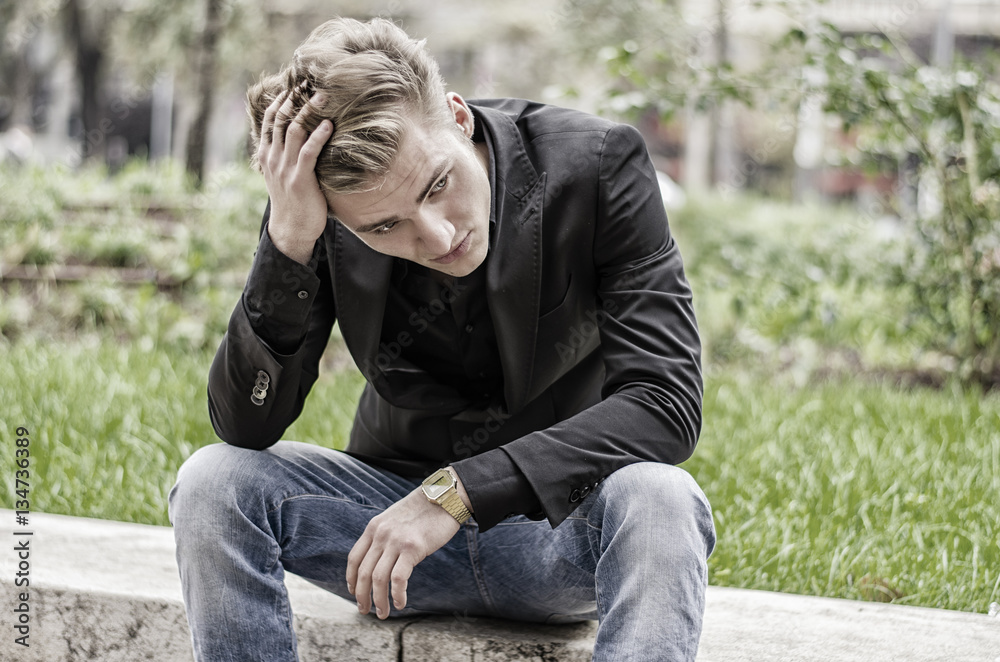 Depressed Young White Man Sitting at Street Side Depressed Young White Man Sitting at Street Side