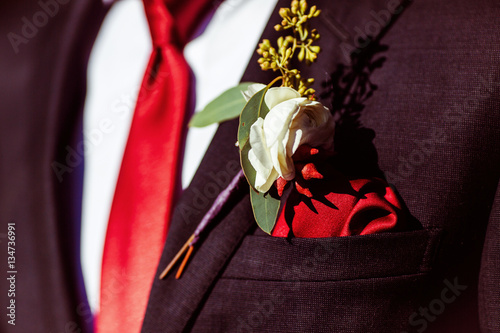 The buttonhole for groom hanging on the costume photo