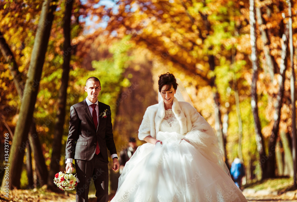 The lovely couple in love walking along park The lovely couple in love walking along park