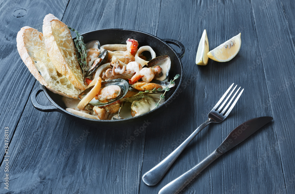 Seafood Stew in Saucepan on dark wood background