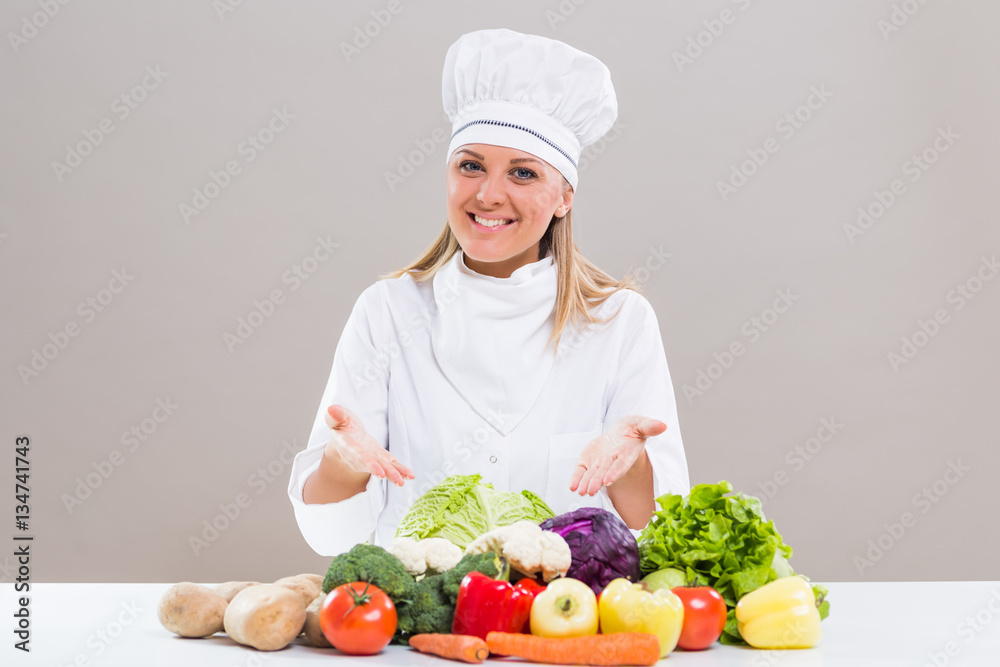 Beautiful chef showing bunch of vegetable Beautiful chef showing bunch of vegetable