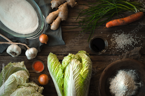 Chinese cabbage kimchi and ingredients on a wooden table