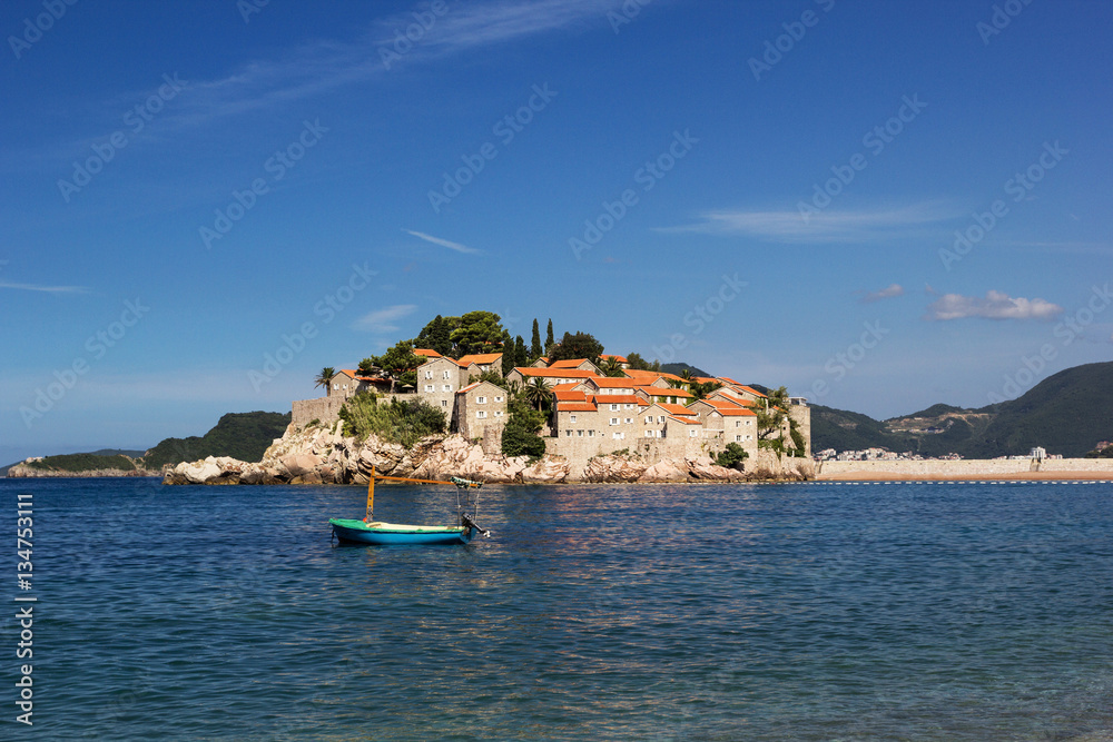 The island of Sveti Stefan. Boat on the foreground.