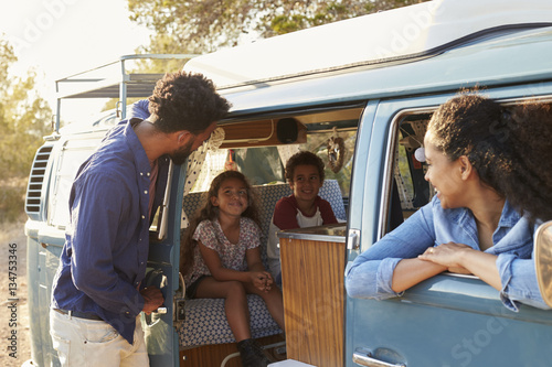 Family on a road trip making a stop in their camper van
