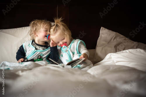 Twins laughing on bed  photo