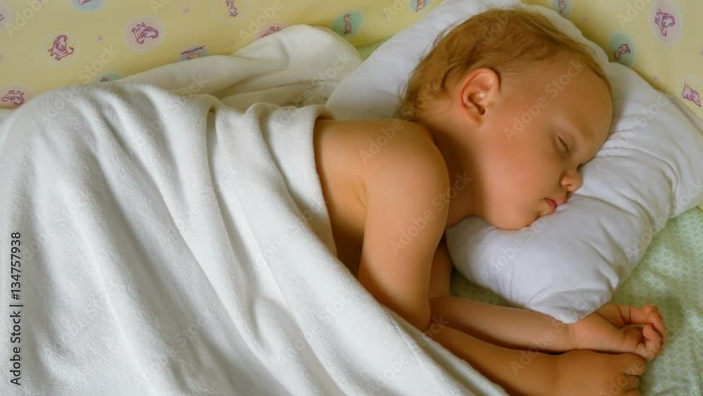 Close-up portrait of a sleeping baby in white bed Close-up portrait of a sleeping baby in white bed