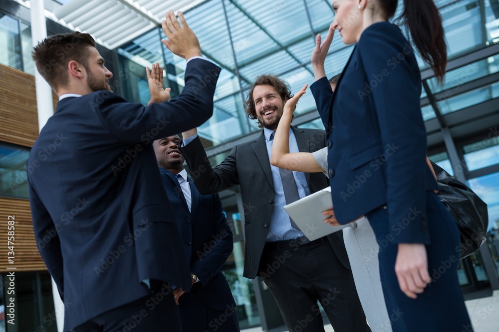 Group of happy businesspeople giving high five to each other Group of happy businesspeople giving high five to each other