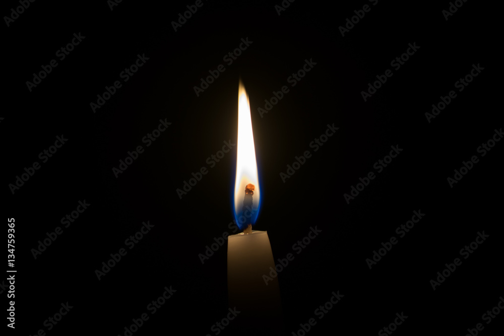 Fototapeta premium Single candle flame in the dark