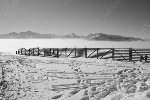 Fence in the snow on the top of the mountain Gaisberg  height approx. 1300 m. A layer of high fog lies over the valley of Salzburg. Austria  Europe.
