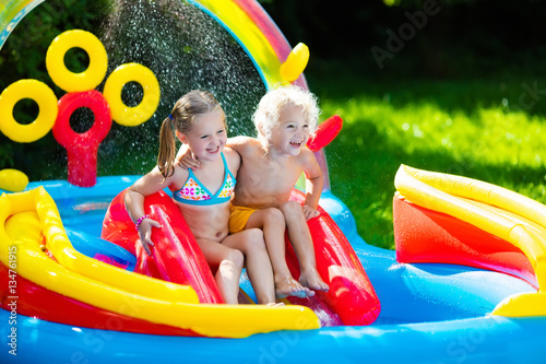 Kids playing in inflatable swimming pool © famveldman