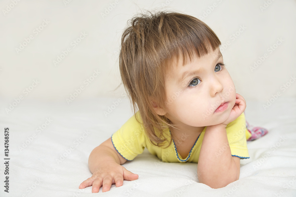 thoughtful child portrait, thinking little girl lying on bed looking away isolated, meditative person thoughtful child portrait, thinking little girl lying on bed looking away isolated, meditative person