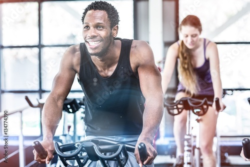 Fit man working out at spinning class