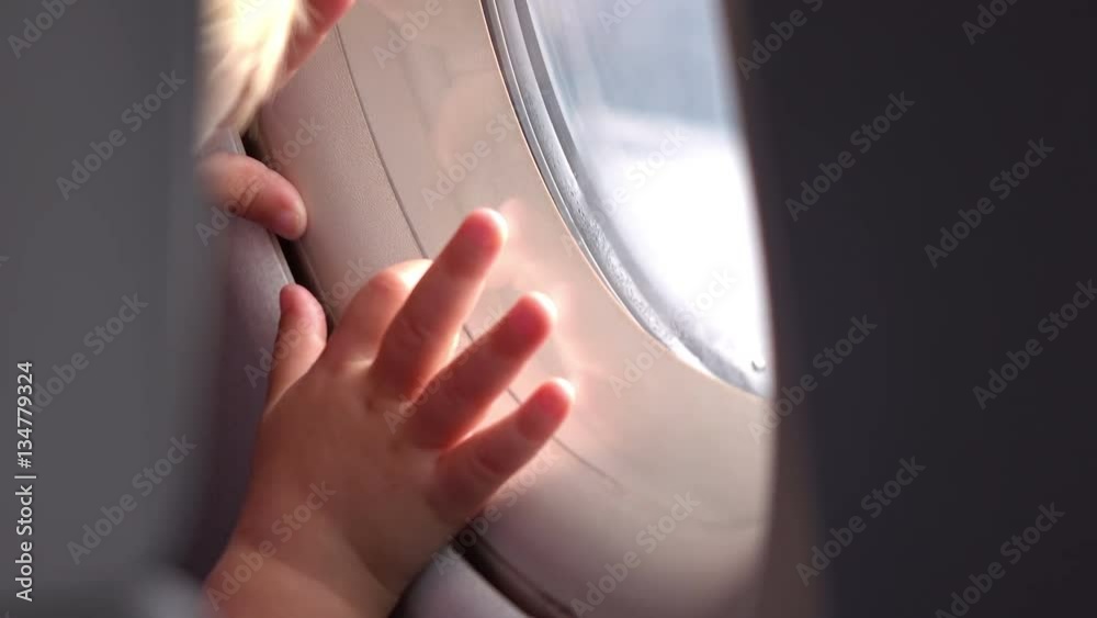 Two videos of child looking through the airplane window in 4K. Two high quality videos of child looking through the airplane window in 4K