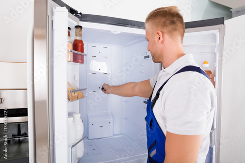 Repairman Fixing Refrigerator