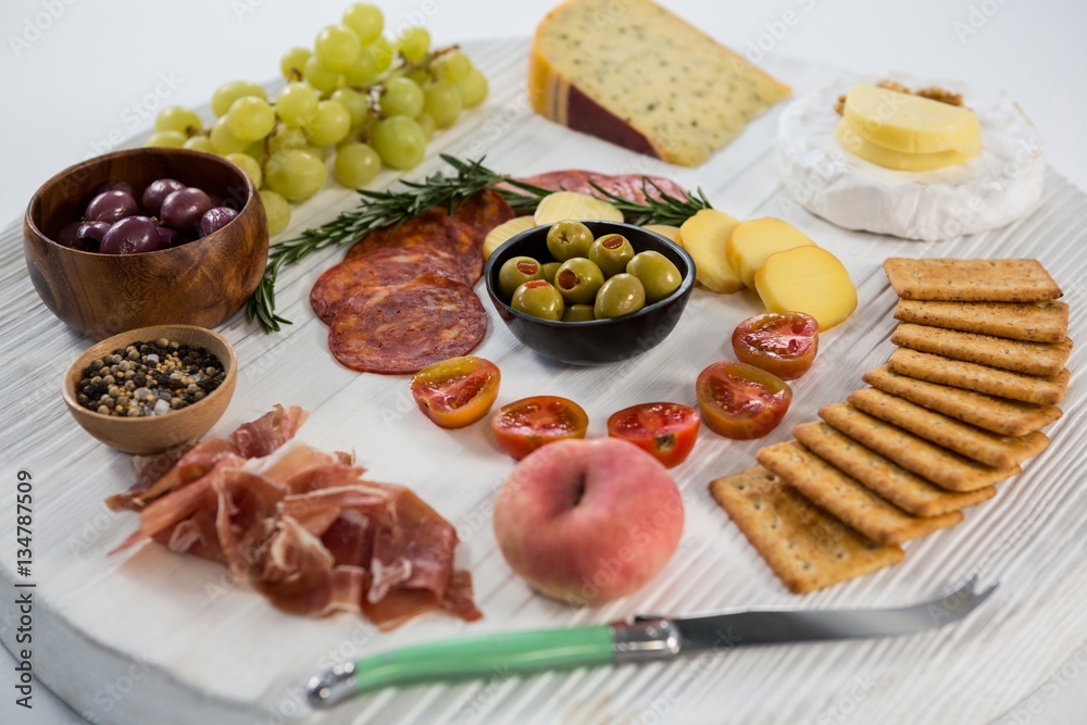 Variety of cheese with grapes, olives, salami