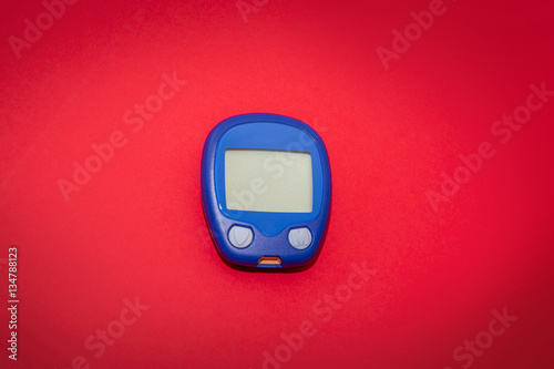 Blank glucometer on red background