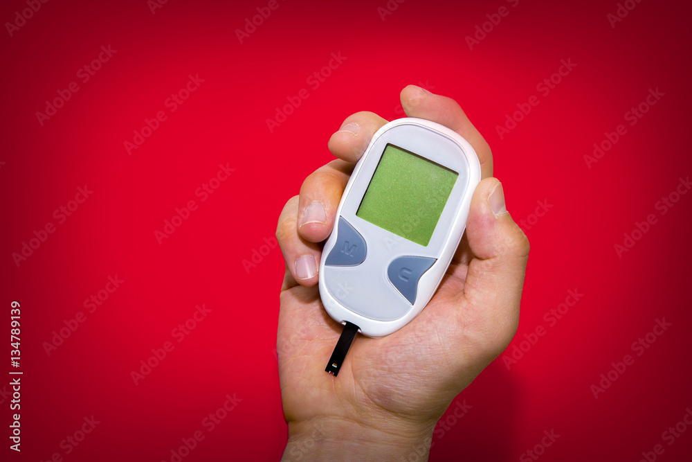 Blank glucometer on red background Blank glucometer on red background