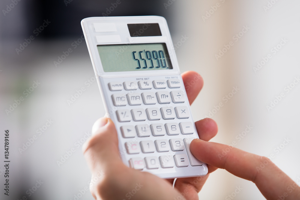 Close-up Of A Person Holding Calculator Close-up Of A Person Holding Calculator