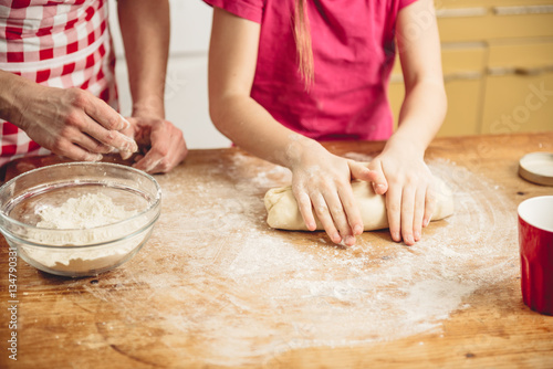 Little girl kneading pizza dough