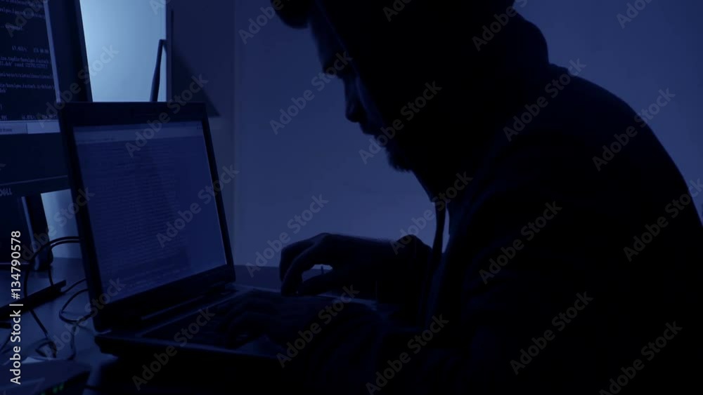 Profile of hackers in the dark while working at the computer Profile of hackers in the dark while working at the computer