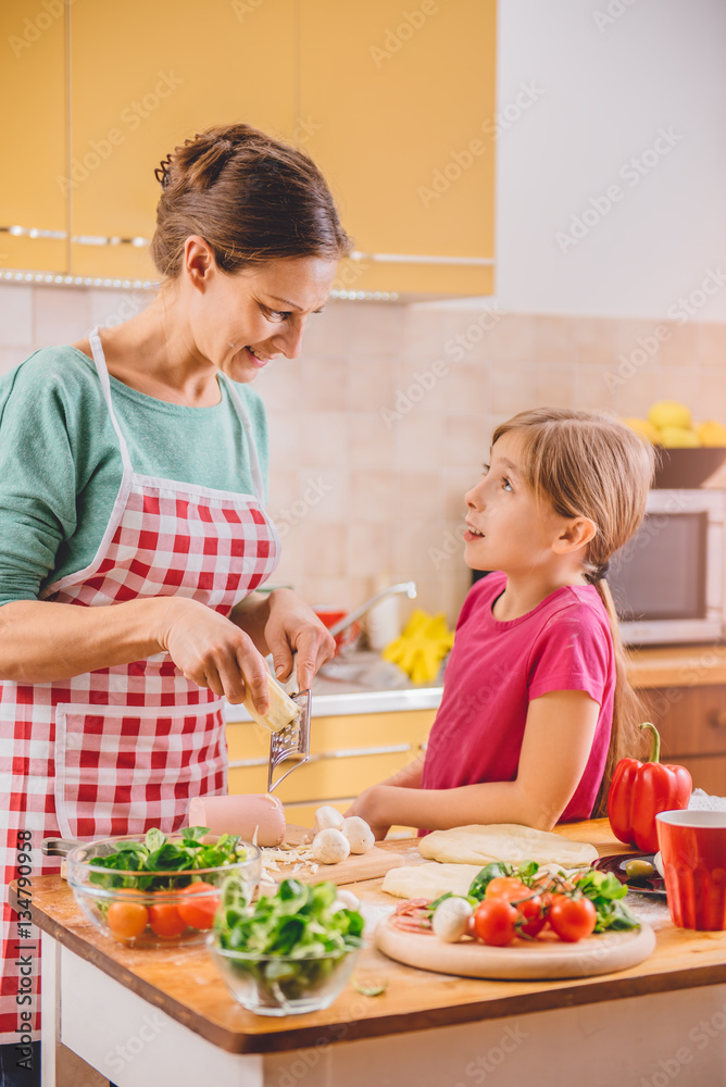 Mother and daughter preparing pizza