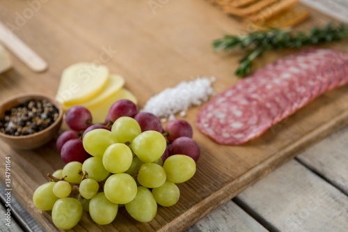 Grapes and ham with various ingredients on chopping board