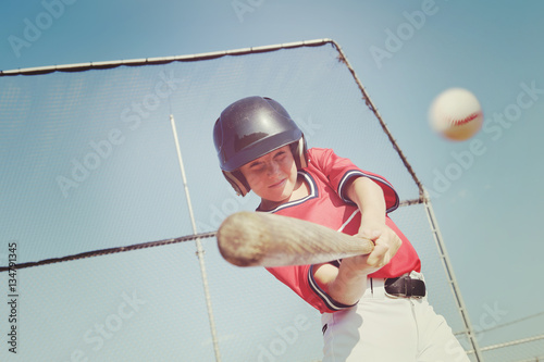 Young baseball player hitting the ball.  Vintage instagram effec