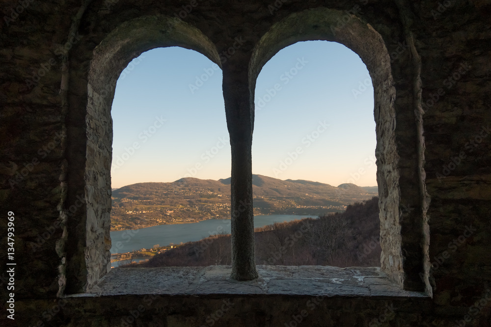 Old arched castle windows with a view on lake and mountains