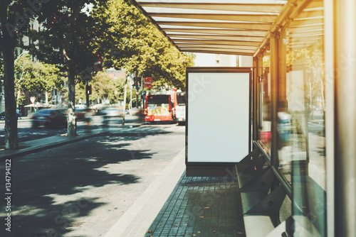 Fototapeta Naklejka Na Ścianę i Meble -  White billboard with copy space area for your text message or promotional content, public information board in urban setting, city bus stop with blank empty mock up banner for your advertising