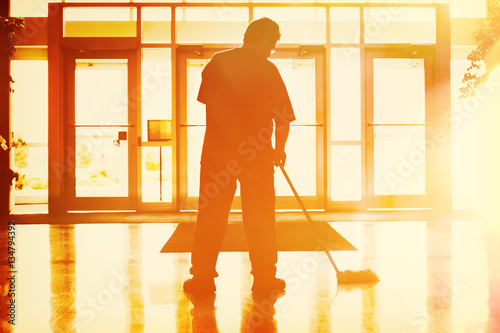 Janitor mopping in an office photo
